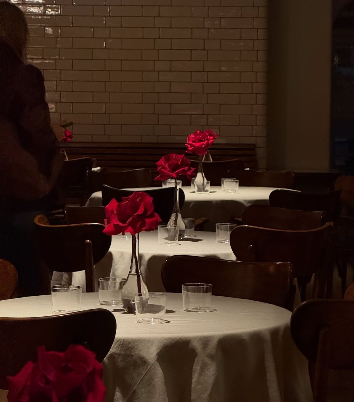 Tables intimistes, roses rouges et lumière tamisée